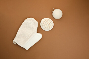 Set eco friendly bath devices. Washcloths and face sponge on a brown background. Flat lay