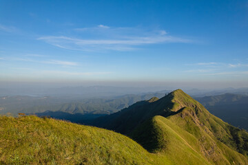 Obraz premium Green yellow mountains and beautiful sky clouds under the blue sky.