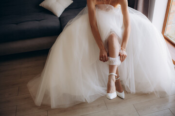 Bride puts on wedding shoes on her tender feet