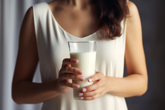 Young woman drinks calciumrich milk for strong bones.