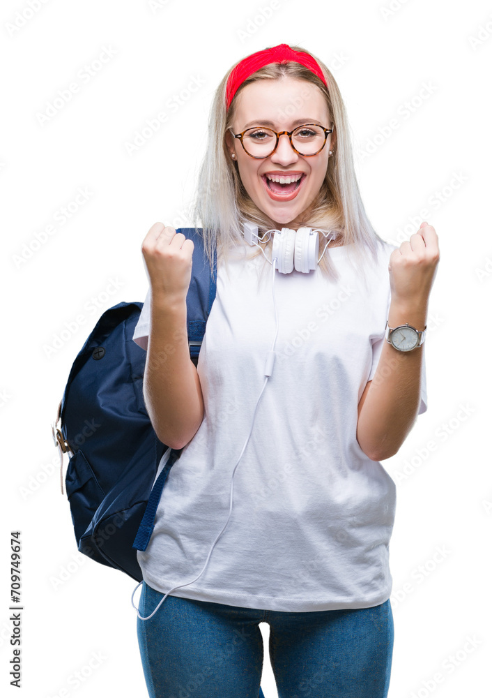 Wall mural Young blonde student woman wearing glasses and backpack over isolated background celebrating surprised and amazed for success with arms raised and open eyes. Winner concept.