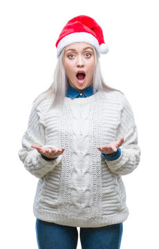 Young blonde woman wearing christmas hat over isolated background afraid and shocked with surprise expression, fear and excited face.