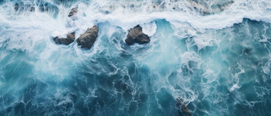 drone footage picture of oceanic blue waves bumping into the rocks - obrazy, fototapety, plakaty
