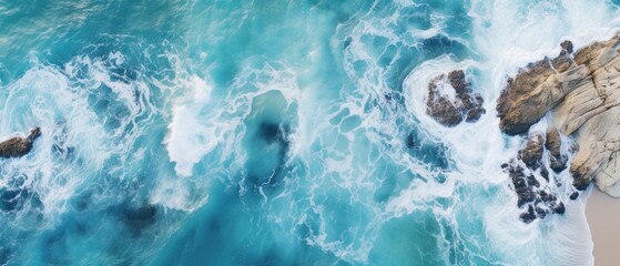 drone footage picture of oceanic blue waves bumping into the rocks - obrazy, fototapety, plakaty