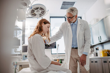 Doctor delivering bad news to teenage patient in hospital, discussing test result in emergency room.