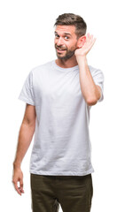 Obraz premium Young handsome man over isolated background smiling with hand over ear listening an hearing to rumor or gossip. Deafness concept.