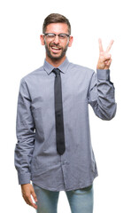 Young handsome business man over isolated background smiling with happy face winking at the camera doing victory sign. Number two.