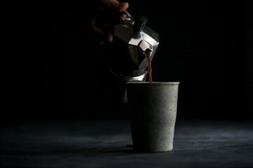 Hand pouring coffee with a moka pot