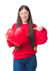 Young Chinese woman wearing graduate uniform red heart very happy pointing with hand and finger
