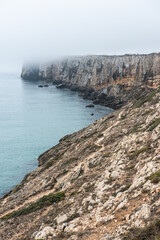 Dramatic cliffs in fog at Atlantic Ocean, Sagres, Algarve, Portugal