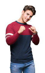 Young handsome man over isolated background looking confident with smile on face, pointing oneself...