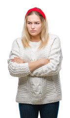 Young caucasian woman wearing winter sweater over isolated background skeptic and nervous, disapproving expression on face with crossed arms. Negative person.