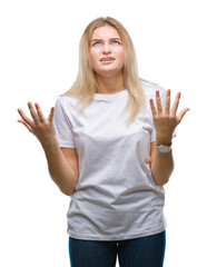 Fototapeta premium Young caucasian woman over isolated background crazy and mad shouting and yelling with aggressive expression and arms raised. Frustration concept.