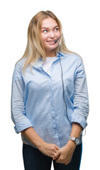 Young caucasian business woman wearing call center headset over isolated background looking away to side with smile on face, natural expression. Laughing confident.