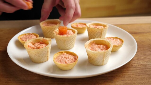 Waffle baskets with pate add salmon and cucumber. Preparation of fish canapés