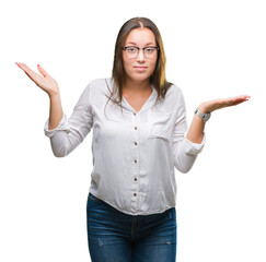 Young caucasian beautiful business woman wearing glasses over isolated background clueless and...