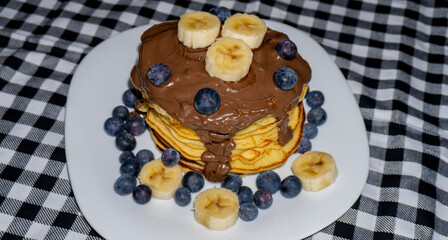 Pancakes with berries and banana slices chocolate cream