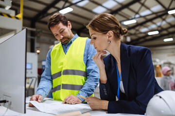 Female warehouse director talking with production manager, discussing new order, preparing products...