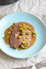 Beef stewed with pickled cucumbers on a blue plate
