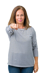 Beautiful middle age woman wearing stripes sweater over isolated background Punching fist to fight, aggressive and angry attack, threat and violence