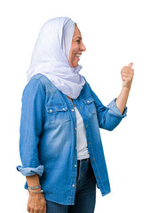 Middle age eastern arab woman wearing arabian hijab over isolated background Looking proud, smiling doing thumbs up gesture to the side