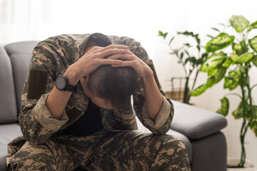 A distraught soldier covering his face, possibly suffering from shell shock or Post Traumatic Stress Disorder