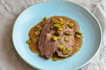 Beef stewed with pickled cucumbers on a blue plate