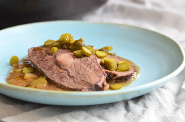 Beef stewed with pickled cucumbers on a blue plate