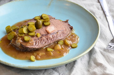 Beef stewed with pickled cucumbers on a blue plate