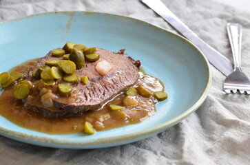 beef filet mignon with sauce and pickled cucumber