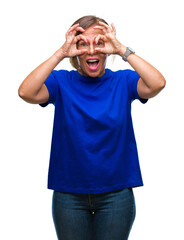 Middle age senior hispanic woman over isolated background doing ok gesture like binoculars sticking tongue out, eyes looking through fingers. Crazy expression.