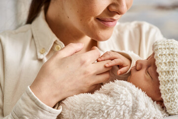 Obraz na płótnie Canvas appealing joyful mother in homewear holding lovingly her newborn baby boy, modern parenting