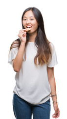 Fototapeta premium Young asian woman eating chocolate chip cookie over isolated background with a confident expression on smart face thinking serious