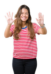 Young beautiful brunette woman wearing stripes t-shirt over isolated background showing and pointing up with fingers number ten while smiling confident and happy.