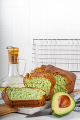 Homemade avocado loaf of bread, keto diet recipe, healthy alternative food idea, on white kitchen background with fresh avocado, copy space