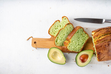 Homemade avocado loaf of bread, keto diet recipe, healthy alternative food idea, on white kitchen background with fresh avocado, copy space