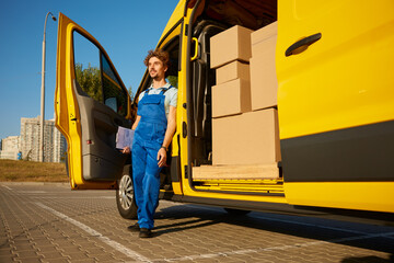 Fototapeta na wymiar Male courier providing cargo delivery or home office moving service
