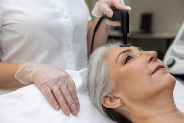 Naklejka premium Beautician doing laser beauty procedures to a woman