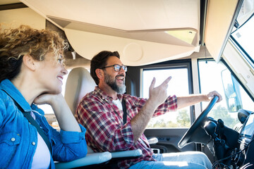 Man driving camper smiles while driving with his wife company. Concept of travel, vacation and life...