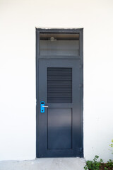 Dirty black door with blue handle after renovation in the house.