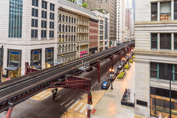 Obraz premium Elevated rail tracks lined with traditional architecture in Chicago downtown on a rainy spring day