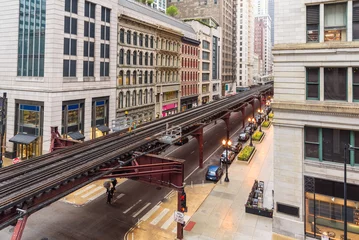 Foto op Plexiglas Elevated rail tracks lined with traditional architecture in Chicago downtown on a rainy spring day © alpegor