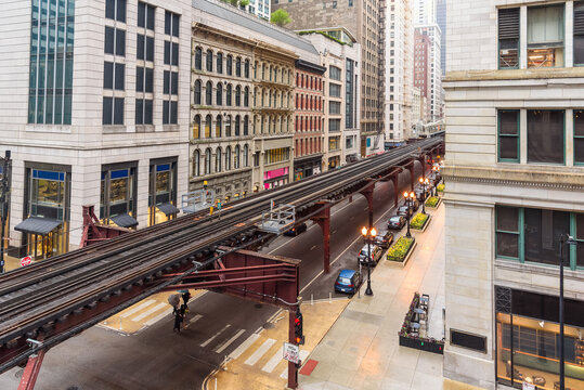 Elevated rail tracks lined with traditional architecture in Chicago downtown on a rainy spring day