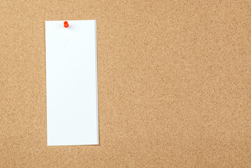 Blank sheet of paper pinned to a cork board. Copy space.