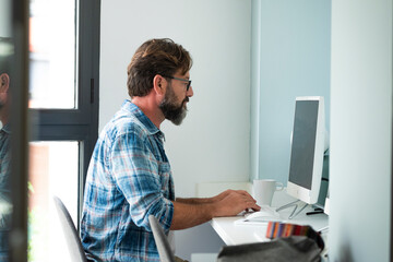 Caucasian freelance people man sitting at the desk typing on desktop computer for online job...