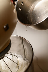 Stand mixer mixes dough for baking macaroon halves close-up