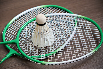 The shuttlecock rests on two badminton rackets. Professional sports equipment. Game.