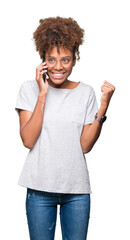 Young african american woman talking on smartphone over isolated background screaming proud and celebrating victory and success very excited, cheering emotion