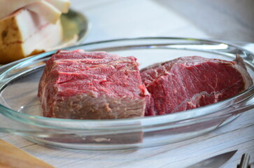 Raw meat in a glass jar on the kitchen table. Selective focus.