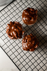 Top view of three macaroons decorated with nuts and chocolate cream
